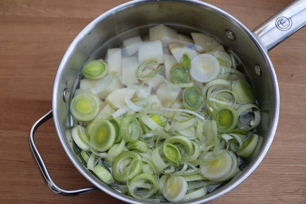 Sliced leeks and chopped potatoes in water in a saucepan.