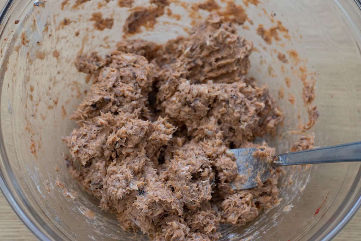 mashed sardine mixture in glass bowl with fork using for mashing
