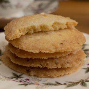 Pile of lemon butter biscuits on saucer, top biscuit broken in half