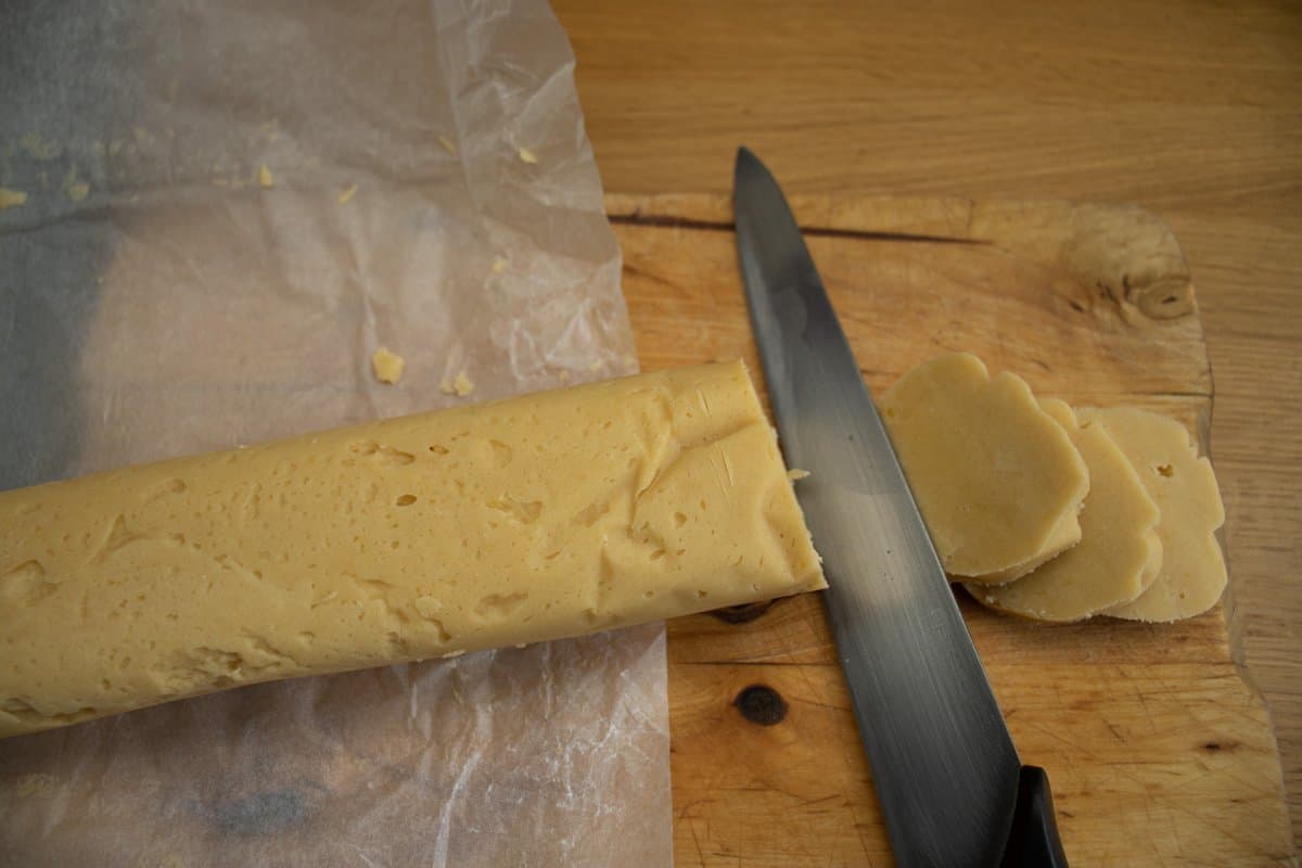 Knife slicing through lemon butter biscuit dough to create biscuit slices