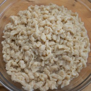 Nokedli in a glass mixing bowl.