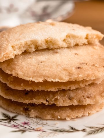 Pile of lemon butter biscuits on a saucer, top biscuit broken in half