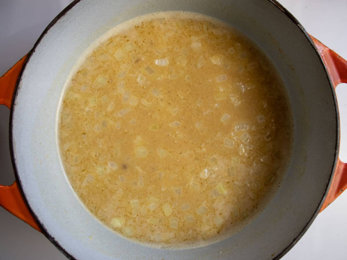 Water, butter and red lentils in enamelled saucepan.