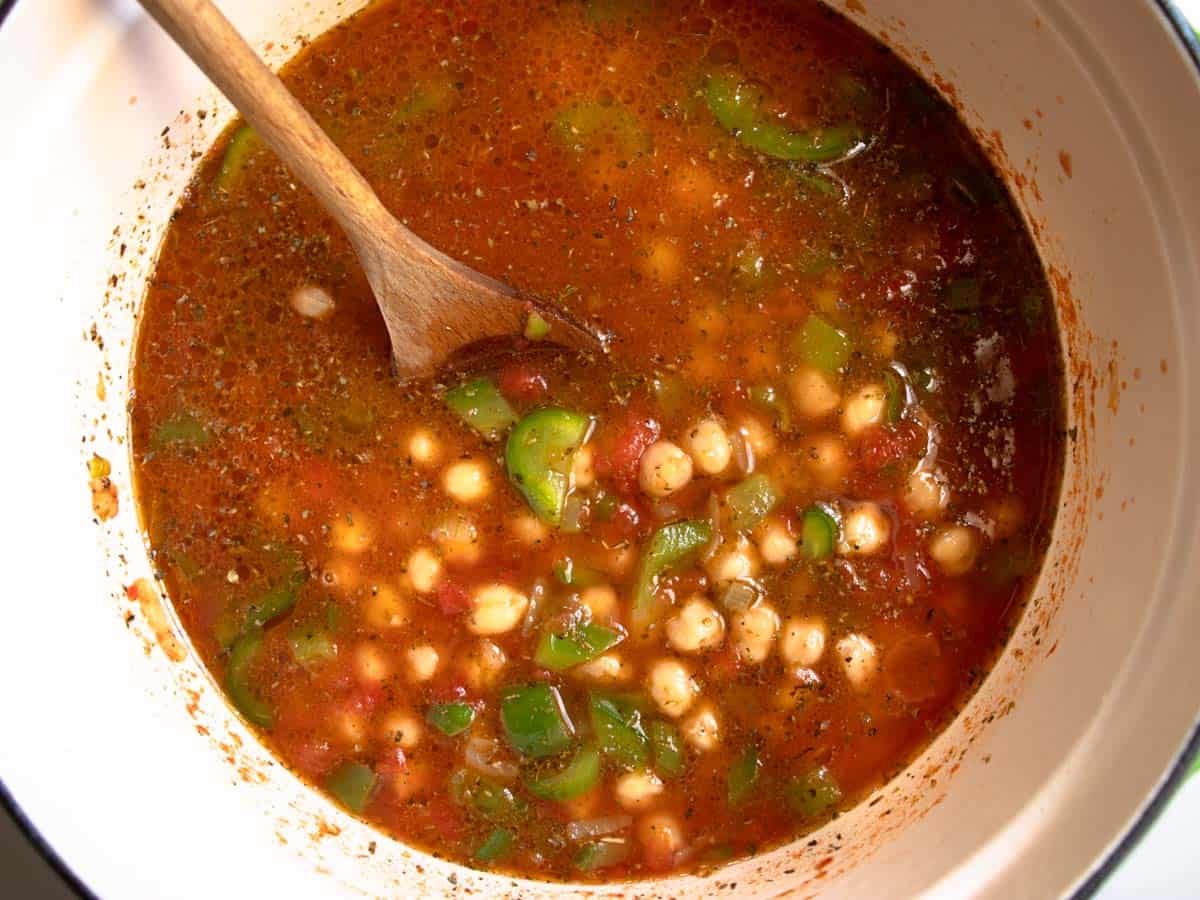 Chickpea and tomato soup with peppers in enamelled saucepan.