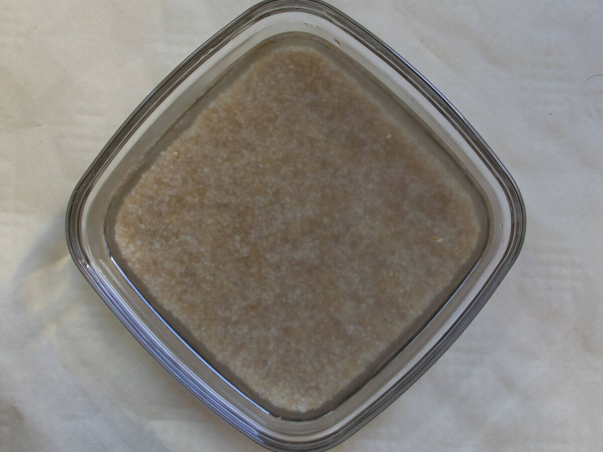 Bulgur wheat soaking in water in glass dish.