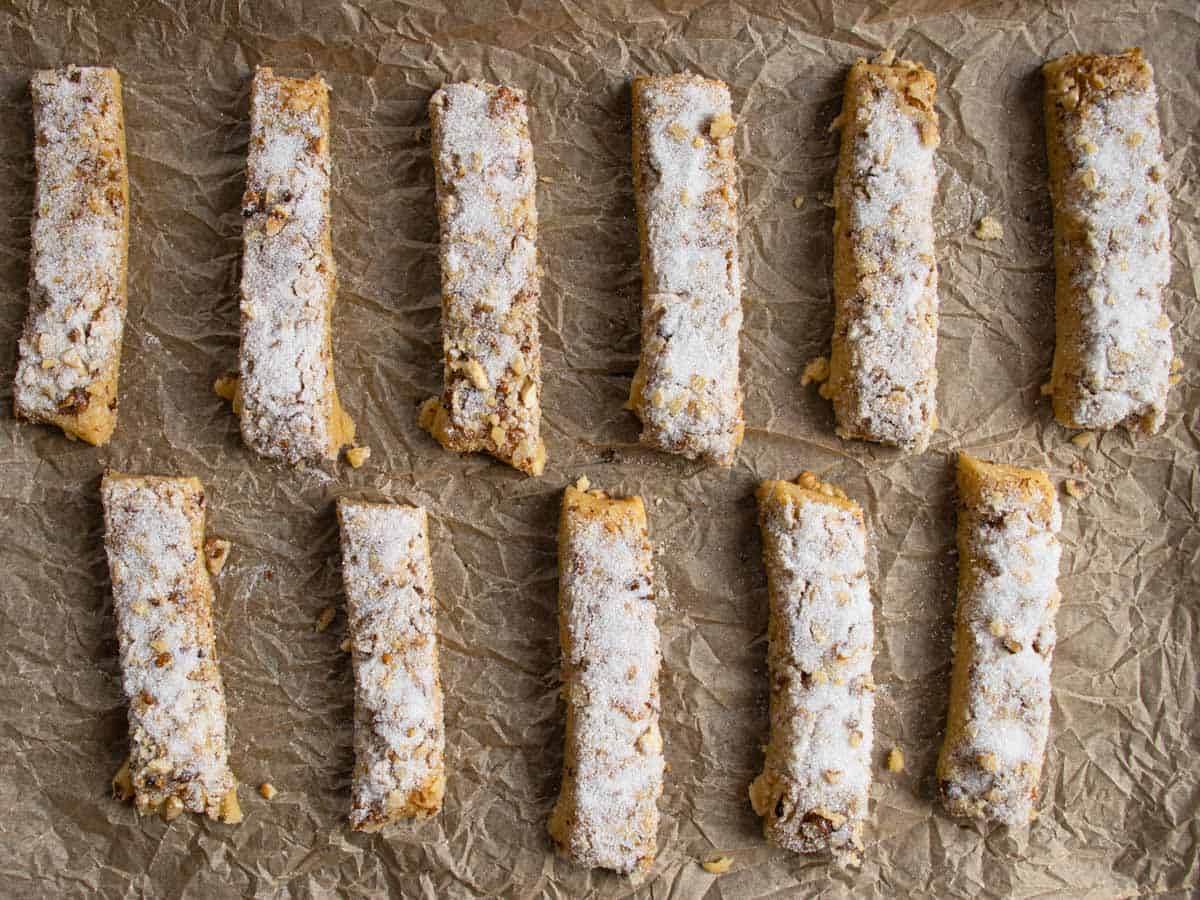 Walnut shortbread cookies laid out on baking paper that has previously been scrunched up.