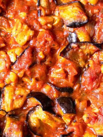 Close up Lebanese Moussaka showing diced roasted aubergines, with chickpeas in a rich tomato sauce.