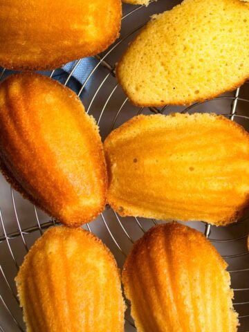 Several French lemon Madeleines on wire tray.